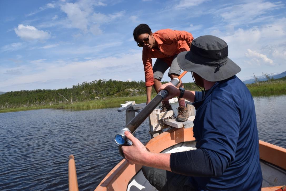 在湖上的一条船上，两个研究生拿着一个研究仪器