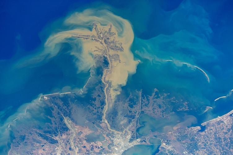 这是一张航拍照片，拍摄的是变色的黄色海水向墨西哥湾的深蓝色海水流动. 